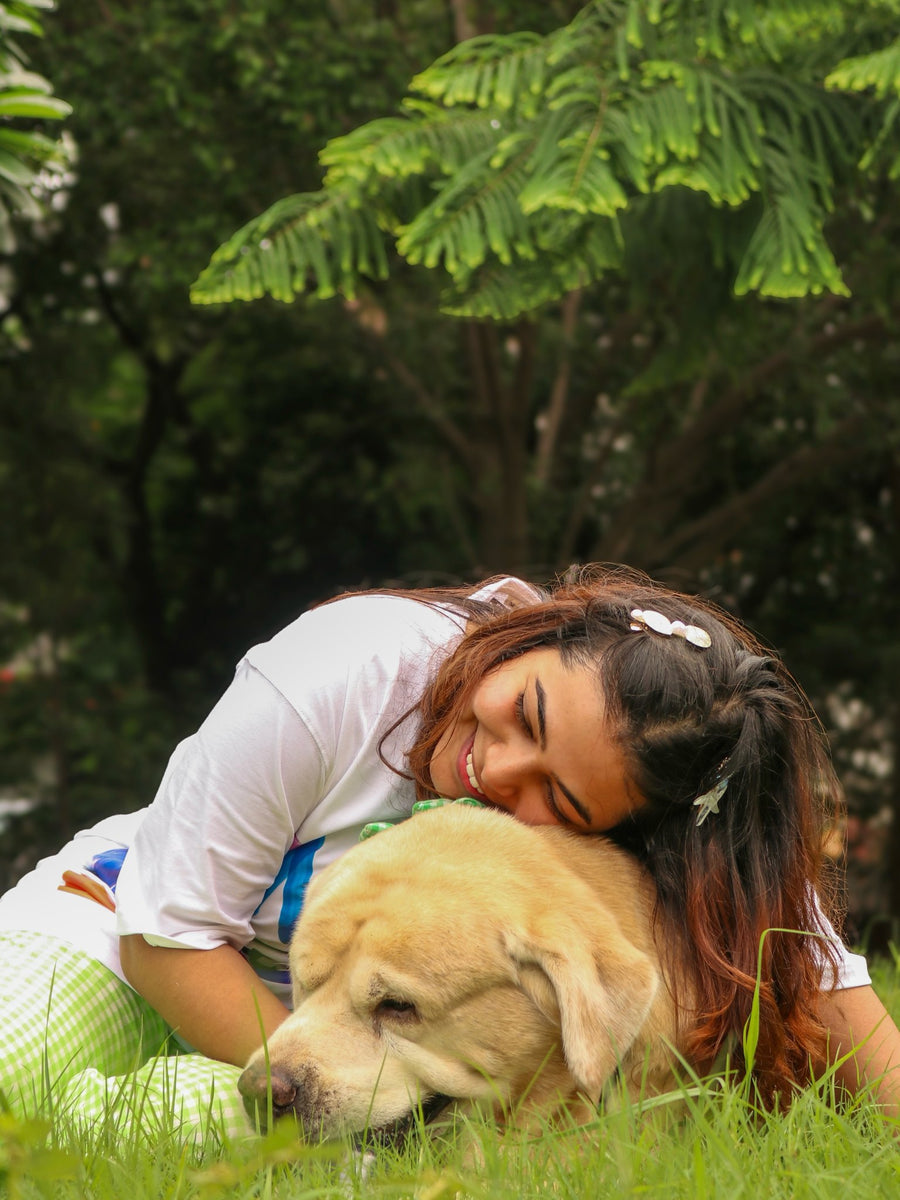 Woman in the In My Dog Mom Era tee hugging her Labrador on the grass
