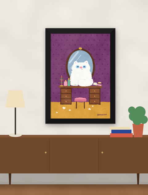 Black framed white persian cat poster hung above a walnut console with a lamp, books and a plant