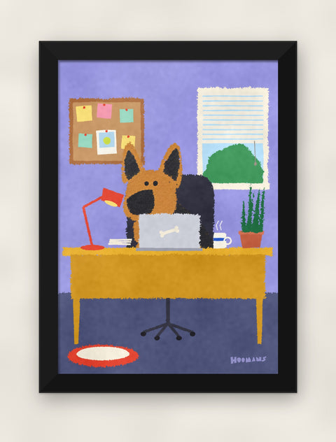 German Shepherd at the Desk art print in a black frame on a plain wall, front view