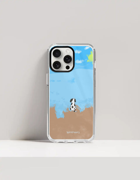 Hoomans Out of Office iPhone case — hand-painted spotted dog on a beach facing the sea, on iPhone 15 Pro mockup