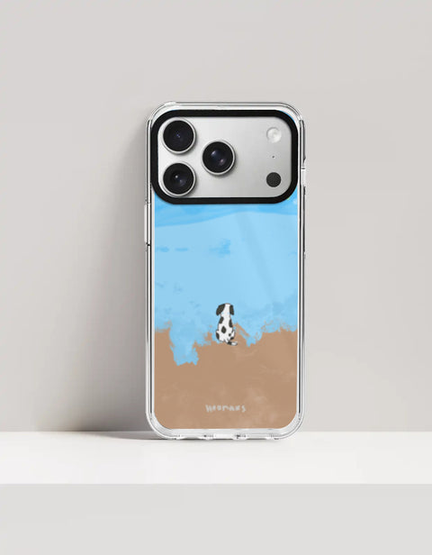 Hoomans Out of Office iPhone case — hand-painted spotted dog on a beach facing the sea, on iPhone 17 Pro Max mockup
