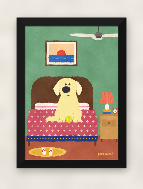 Labrador on the Bed art print in a black frame on a plain wall, front view