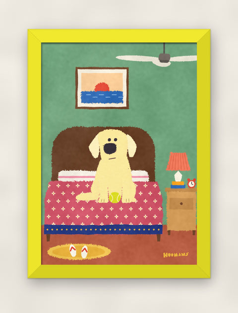 Labrador on the Bed art print in a yellow frame on a plain wall