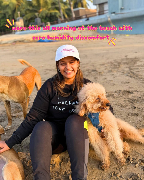 Real customer wearing the Dogs Are My Favourite People cap on the beach with street dogs, Hoomans India