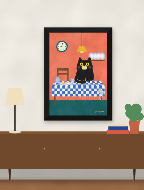 Black framed black cat poster hung above a walnut console with a lamp, books and a plant