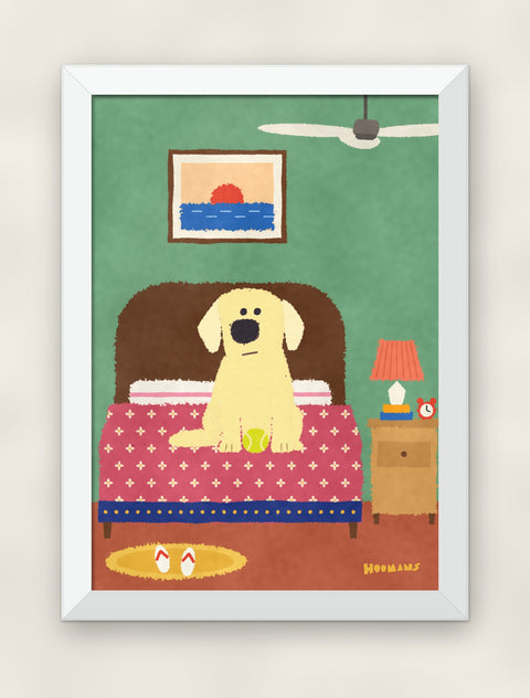 Labrador on the Bed art print in a white frame on a plain wall