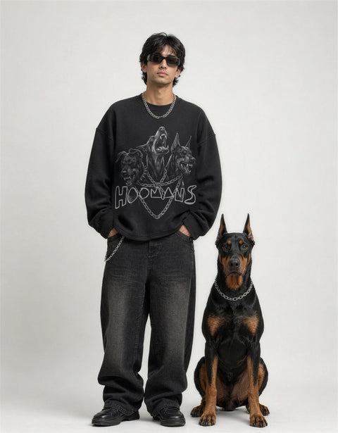 Man wearing the black waffle knit oversized full sleeve tee with the three dobermans print, standing next to a doberman