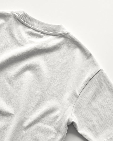Back neckline and drop shoulder of the white oversized tee