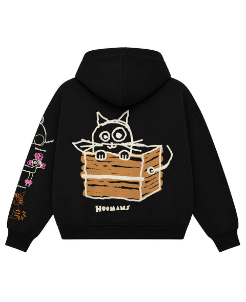 Back of the black boxy hoodie with a big crudely drawn cat sitting in a cardboard box, flat lay