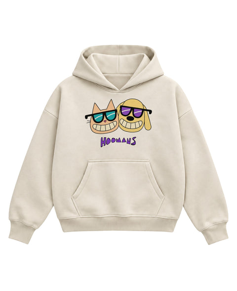 Cream boxy hoodie with a peach cartoon cat and a yellow cartoon dog cheek to cheek, both in sunglasses and grinning, above a purple HOOMANS wordmark, front flat lay