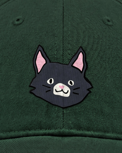 Embroidered black cat face in satin stitch on a bottle green baseball cap, close up