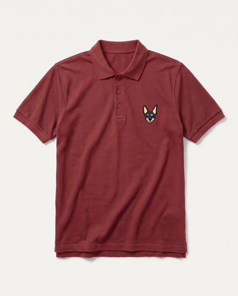 Brick Red polo shirt with embroidered black indie dog face on the chest, front flat lay
