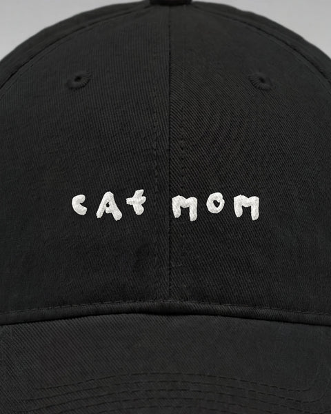 Close-up of the embroidered white cat mom lettering on the front of the black cap