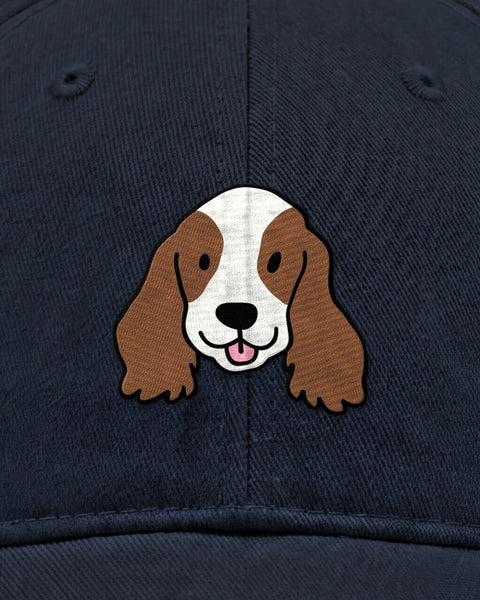 Embroidered cocker spaniel face in satin stitch on a navy blue baseball cap, close up