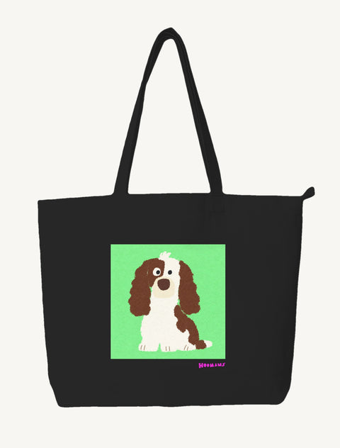 Black large canvas tote bag with a flat colour brown and white Cocker Spaniel sitting on a mint green block and an orchid Hoomans wordmark, front view