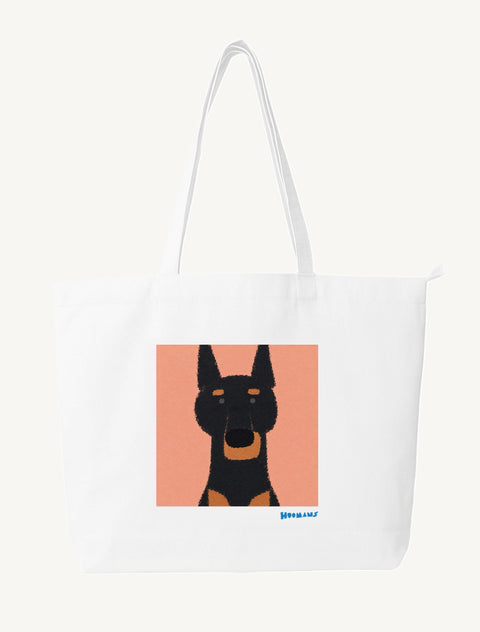 White large canvas tote bag with a flat colour black and tan Doberman on a peach block and a cerulean blue Hoomans wordmark, front view