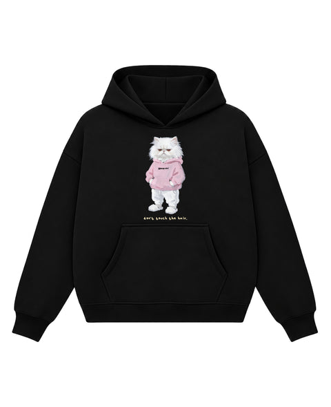 Black boxy hoodie with a painted white persian cat in a pink hoodie and fluffy slippers above the line 'don't touch the hair.', front flat lay