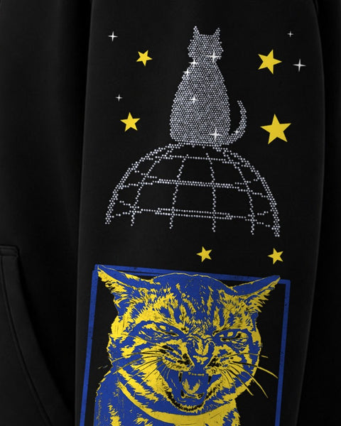 Close up of the left sleeve: a sparkling cat sitting on a globe under yellow stars, above a blue and yellow hissing tabby