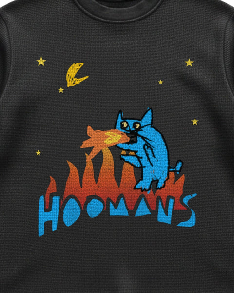 Close up of the flame cat print on black waffle knit: the blue cat, the flames and the HOOMANS wordmark, with the knit texture showing through the ink