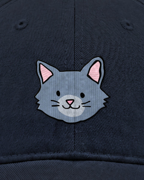 Embroidered grey cat face in satin stitch on a navy blue baseball cap, close up