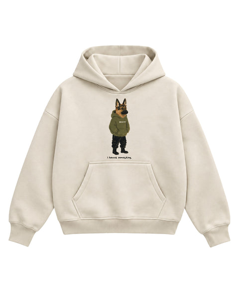 Cream boxy hoodie with a painted german shepherd in an olive hoodie, cargo pants and boots, ears up, above the line 'i heard something.', front flat lay