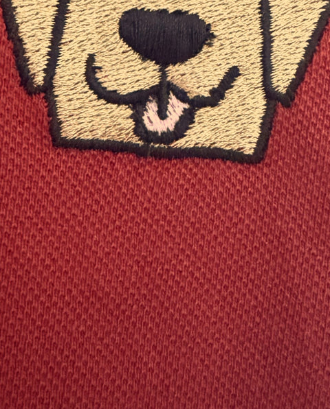 Macro of the Lab Polo embroidery showing the stitch texture and the piqué knit below it, Brick Red