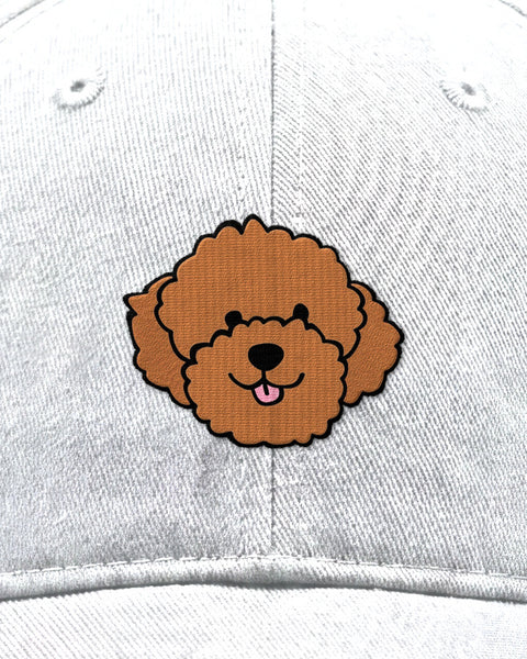 Embroidered poodle face in satin stitch on a white baseball cap, close up