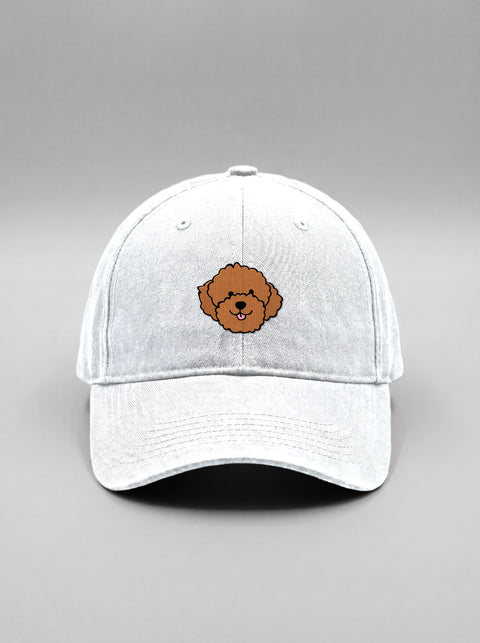 White baseball cap with embroidered poodle face, front view
