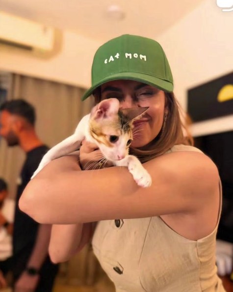 kanupriya1707 in the Hoomans Cat Mom cap, holding her cat