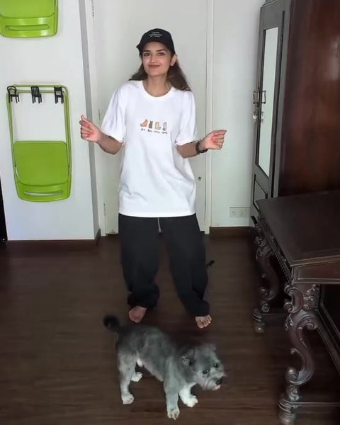 Tara Alisha Berry in a Hoomans tee and cap with her dog