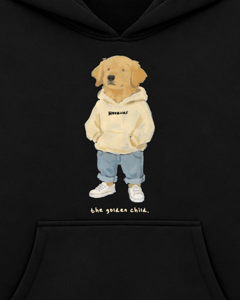Close up of the chest print: a golden retriever standing in a cream HOOMANS hoodie with its paws in the pocket, above 'the golden child.'