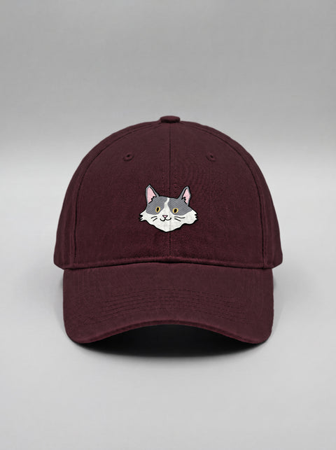 Maroon baseball cap with embroidered white and grey cat face, front view