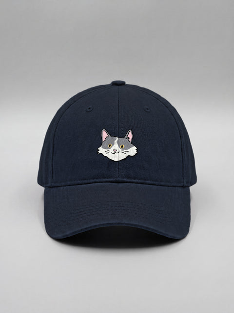 Navy blue baseball cap with embroidered white and grey cat face, front view