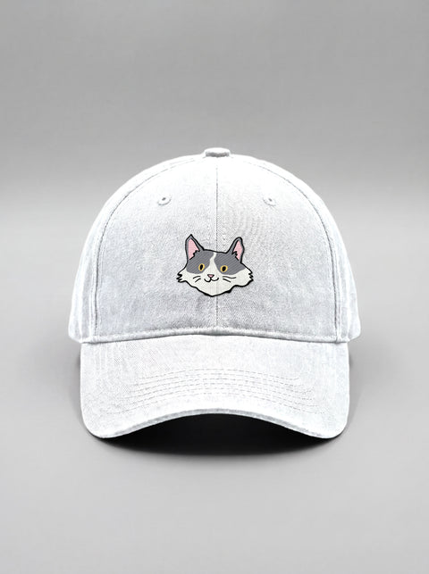 White baseball cap with embroidered white and grey cat face, front view