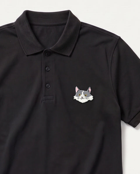 Black embroidered white and grey cat polo, close-up of collar, button placket, and satin-stitch chest patch