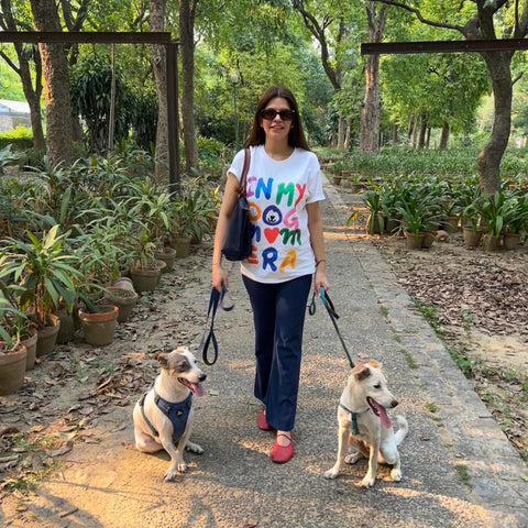 Real customer wearing the In My Dog Mom Era oversized tee while walking her two dogs, Hoomans India