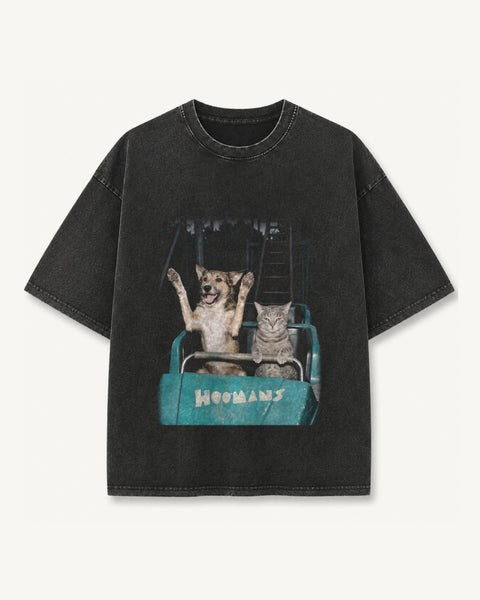 Black vintage wash oversized tee with a faded ride photo of a dog with both paws up and an unimpressed cat on a teal roller coaster, front flat lay